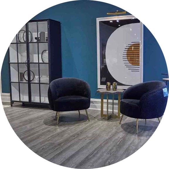 two dark blue chairs with a glass front cabinet